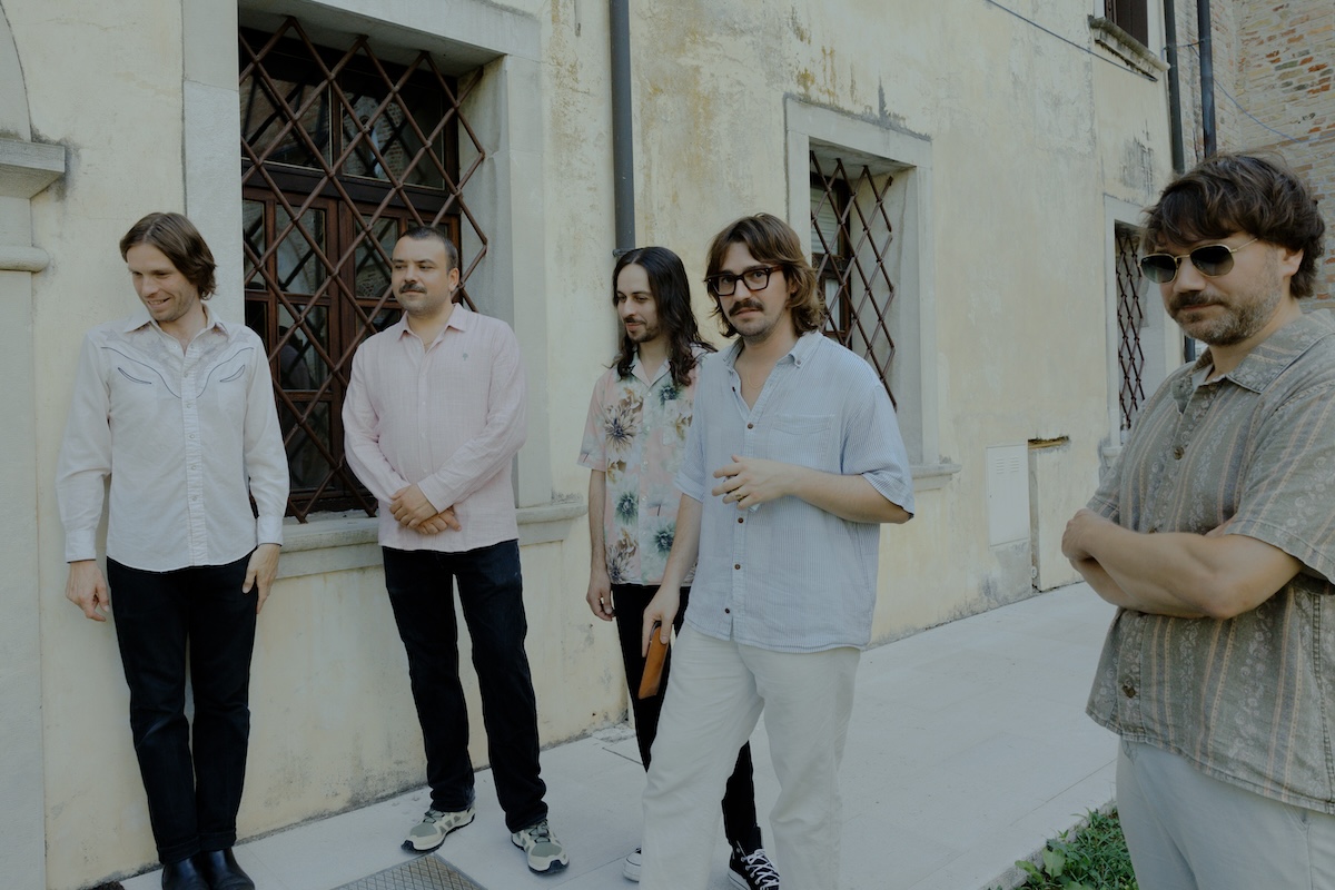 Psych-rock band Altın Gün posing outdoors against a light building wall.